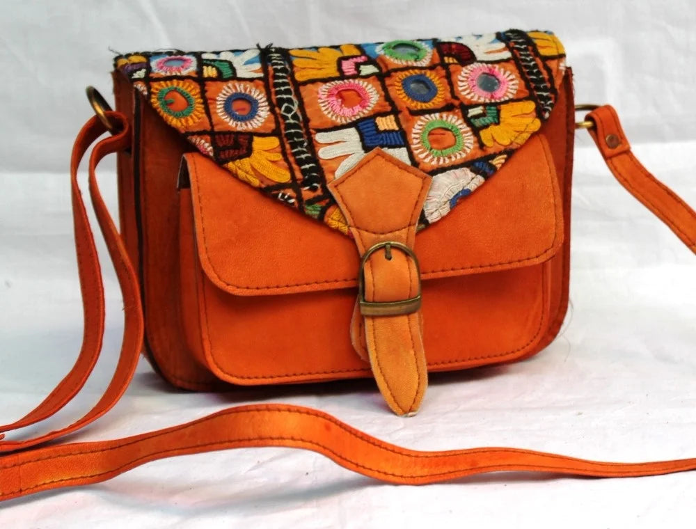 Vintage ethnic leather crossbody bag featuring colorful embroidered flap and orange leather body.