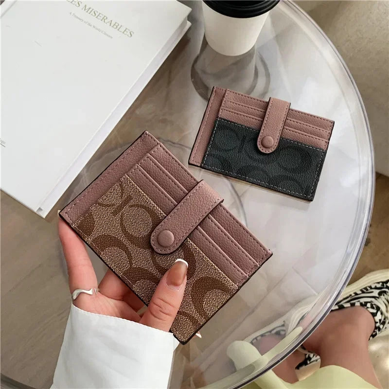 Compact RFID wallet for women in various colors displayed on a table with accessories.