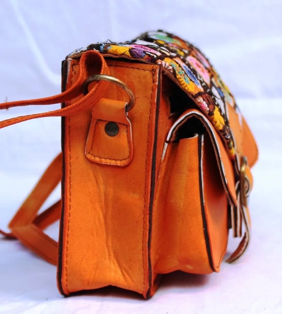 Side view of a vintage ethnic leather crossbody bag showcasing its vibrant color and intricate design.