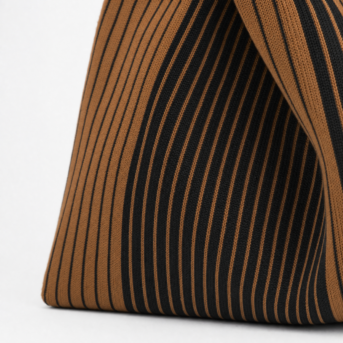 Close-up of a brown everyday tote bag with a black striped design, showcasing its stylish texture and versatility.