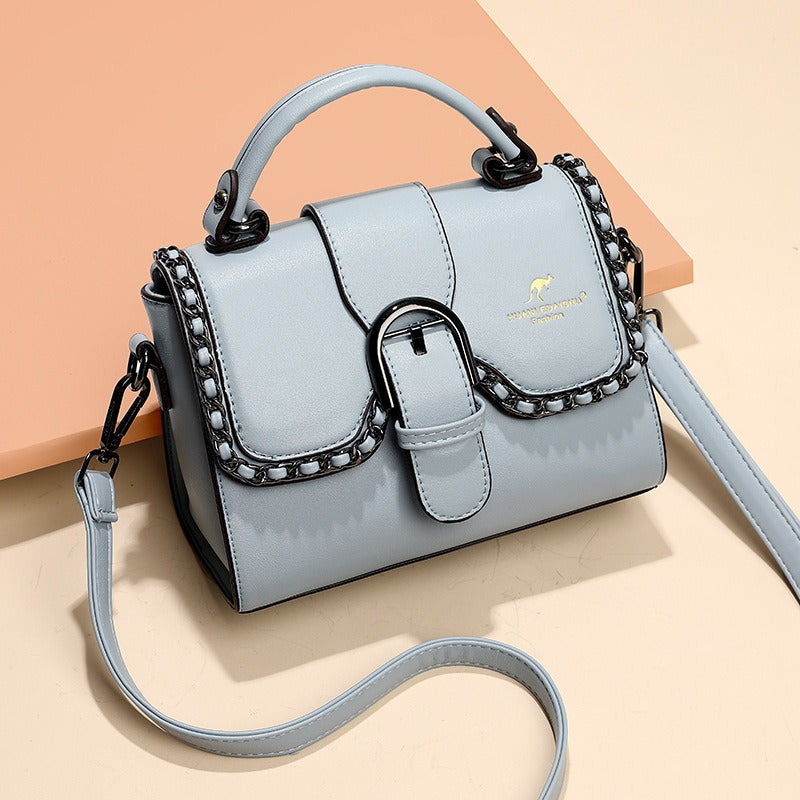 luxury PU shoulder bag for women in light blue with magnetic buckle and chain detail.